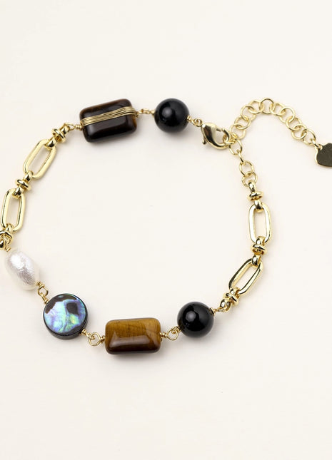 Gold-plated chain bracelet featuring tiger's eye, obsidian, freshwater pearls and abalone shell on white background