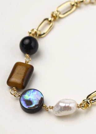 Gold-plated chain bracelet featuring tiger's eye, obsidian, freshwater pearls and abalone shell on white background