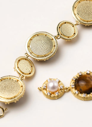 Ornate gold-plated bracelet with alternating brown tiger's eye stones and white freshwater pearls in crystal-accented settings
