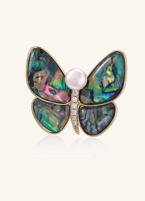 Iridescent abalone shell butterfly pin with central pearl and gold setting, showing rainbow color reflections