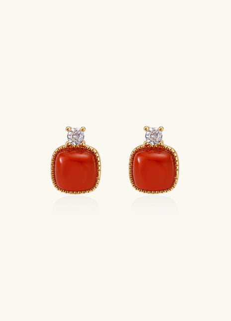 Gold-plated sterling silver stud earrings with square south red agate stones and clear crystals on cream background