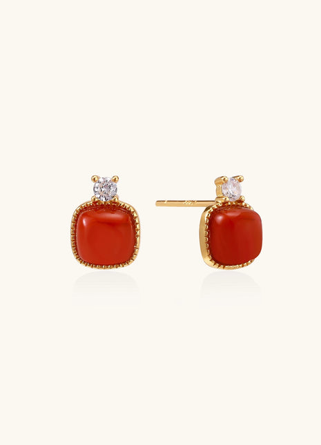 Gold-plated sterling silver stud earrings with square south red agate stones and clear crystals on cream background