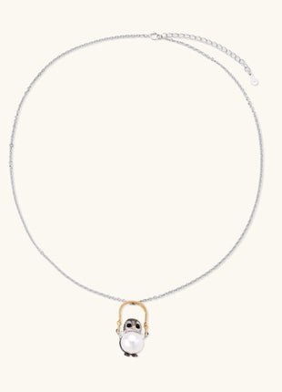 Silver owl pendant holding a round freshwater pearl on an adjustable chain against white background