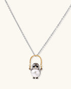 Silver owl pendant holding a round freshwater pearl on an adjustable chain against white background