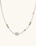 Delicate sterling silver necklace with freshwater pearls, green serpentine centerpiece, and mixed agate beads on white background.