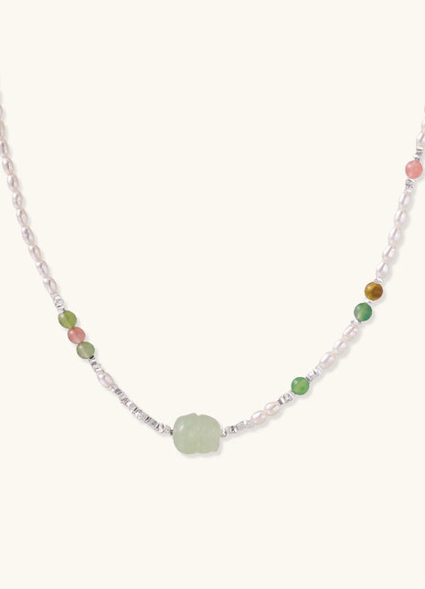 Delicate sterling silver necklace with freshwater pearls, green serpentine centerpiece, and mixed agate beads on white background.