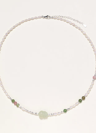 Delicate sterling silver necklace with freshwater pearls, green serpentine centerpiece, and mixed agate beads on white background.