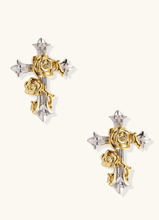 Two-tone cross earrings with gold roses and silver base featuring crystal accents on beige background.