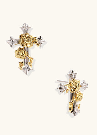 Two-tone cross earrings with gold roses and silver base featuring crystal accents on beige background.