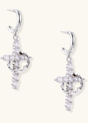Ornate cross dangle earrings with zirconia stones and gold-plated brass construction on white background.