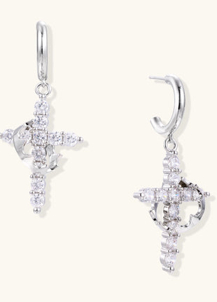 Ornate cross dangle earrings with zirconia stones and gold-plated brass construction on white background.