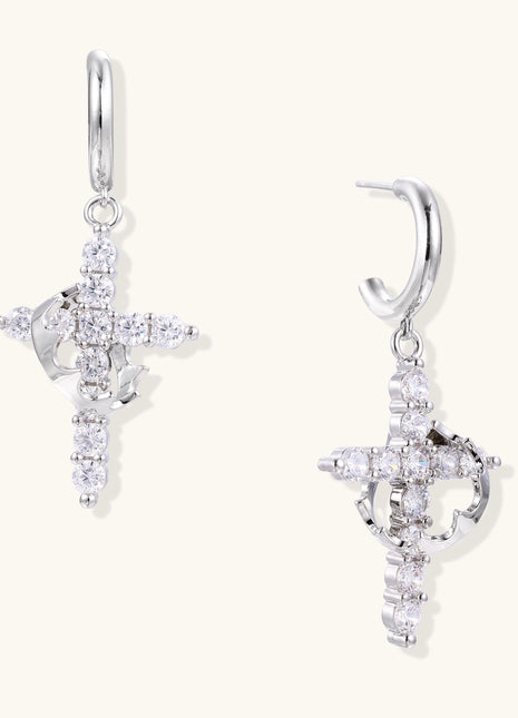 Ornate cross dangle earrings with zirconia stones and gold-plated brass construction on white background.