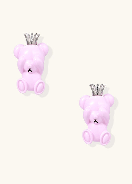 Pair of pink teddy bear-shaped stud earrings with silver crowns on white background, made from gold-plated brass
