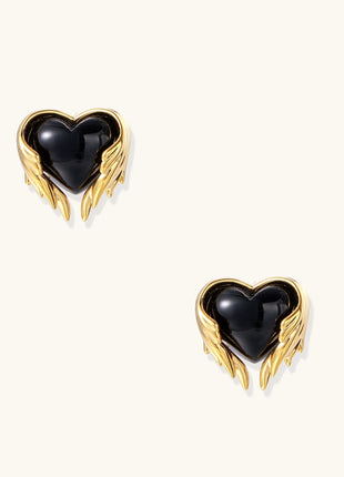 Pair of 18K gold plated earrings with wing design surrounding black resin heart centers on light background