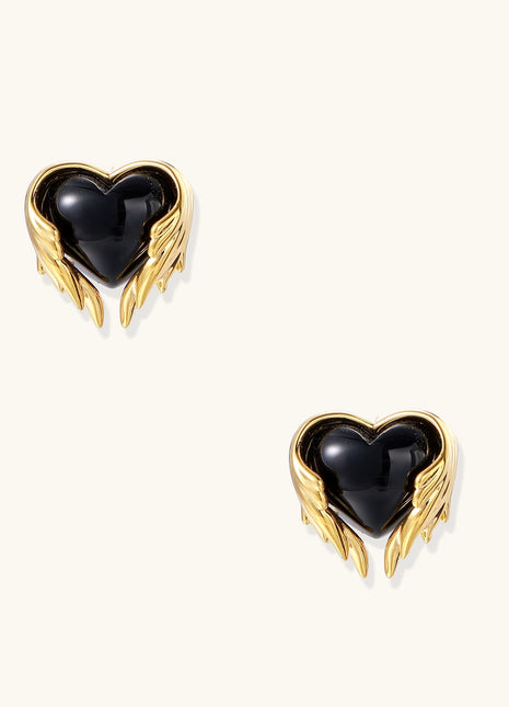 Pair of 18K gold plated earrings with wing design surrounding black resin heart centers on light background