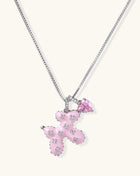 Pink enamel cross pendant with zirconia crystals and teardrop charm on 18K gold-plated chain against white background