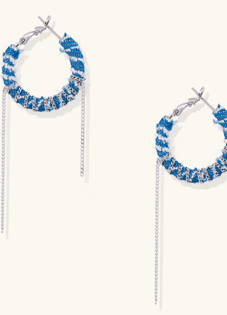 Blue and white checkered denim-wrapped hoop earrings with delicate silver chain dangles on neutral background