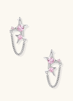 Gold-plated star earrings with pink zirconia stones connected by delicate chains on light background