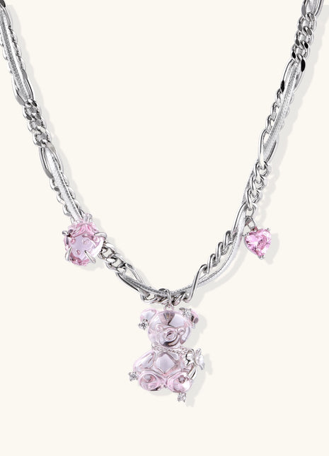 Adjustable gold-plated brass chain necklace with pink zirconia crystals and mixed link patterns on white background.