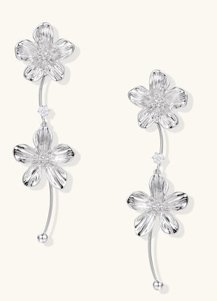 Gold-plated floral dangle earrings with zirconia crystal centers and curved stems on white background.
