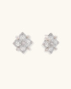 Detailed view of sterling silver stud earrings with geometric filigree design and small freshwater pearls on white background.
