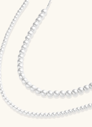 Sterling silver necklace with graduated pearl beads and delicate chain sections featuring a toggle clasp closure.
