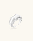 Chunky sterling silver ring with organic flowing design and brushed matte finish on neutral background