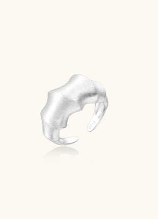 Chunky sterling silver ring with organic flowing design and brushed matte finish on neutral background