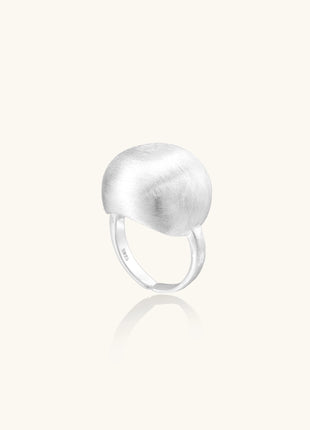 Minimalist sterling silver ring with large brushed disc top and adjustable band on white background.