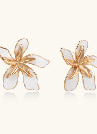 Large floral stud earrings with gold-plated brass petals and white enamel centers on neutral background