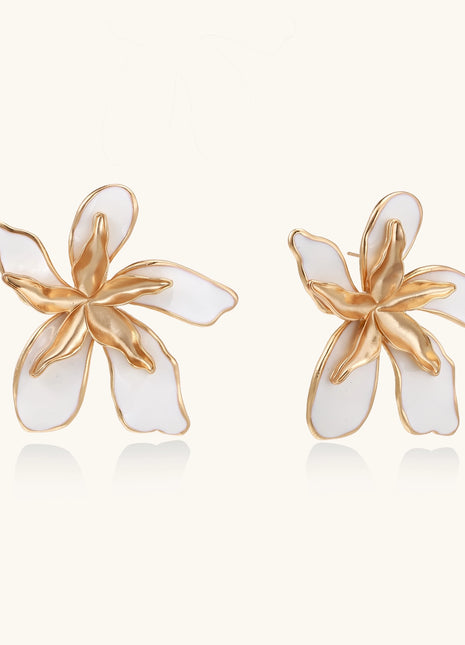 Large floral stud earrings with gold-plated brass petals and white enamel centers on neutral background