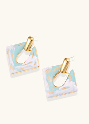 Diamond-shaped gold-plated earrings with pastel marble enamel in turquoise and lavender swirls on beige background