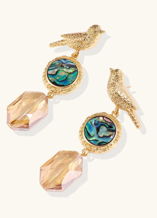 Gold-plated bird dangle earrings with iridescent abalone shell discs and champagne crystal drops on white background.