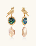 Gold-plated bird dangle earrings with iridescent abalone shell discs and champagne crystal drops on white background.