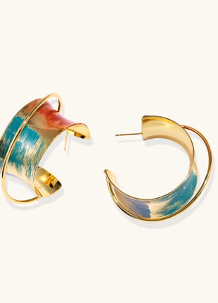 Gold-plated hoop earrings with colorful enamel brushstroke patterns in turquoise, coral, and gold tones