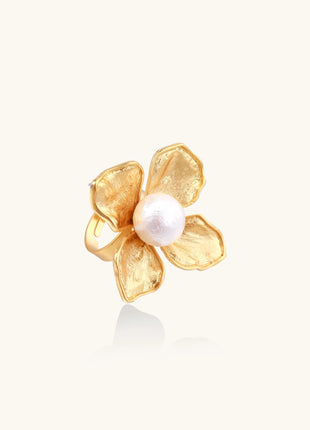 Gold-plated brass ring with dimensional 5-petal flower design and white cotton pearl center on neutral background.