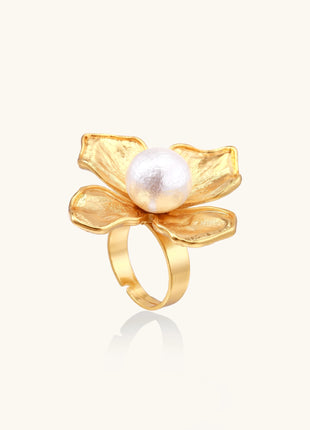 Gold-plated brass ring with dimensional 5-petal flower design and white cotton pearl center on neutral background.
