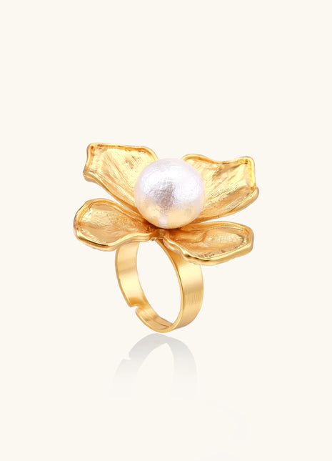 Gold-plated brass ring with dimensional 5-petal flower design and white cotton pearl center on neutral background.