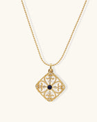 Gold-plated square pendant with ornate scrollwork featuring central blue lapis lazuli stone on ball chain