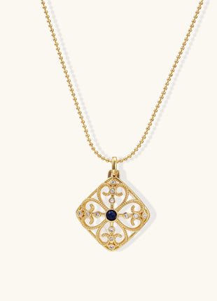 Gold-plated square pendant with ornate scrollwork featuring central blue lapis lazuli stone on ball chain