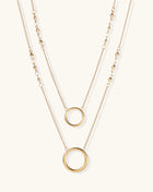 Gold-plated layered necklace set with two circular pendants featuring white centers on delicate chains.