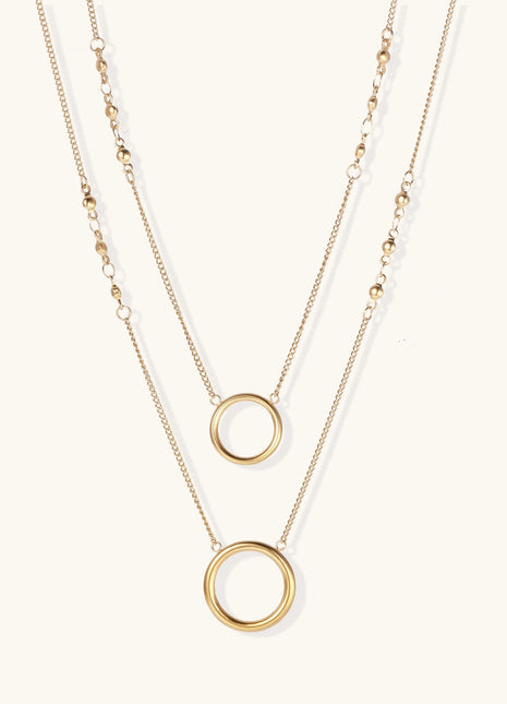 Gold-plated layered necklace set with two circular pendants featuring white centers on delicate chains.