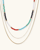 Layered gold-plated necklace set featuring colorful crystal beads in turquoise, green, black, red, and clear tones