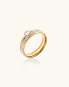 14K gold plated ring with center rhinestone and accent stones along the band on white background.