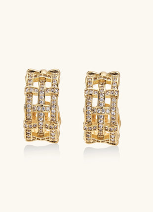 Close-up of geometric gold-plated hoop earrings with crystal pave in intricate lattice pattern on neutral background.