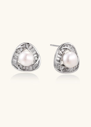 Close-up of triangular gold-plated stud earrings with central freshwater pearl surrounded by baguette crystals