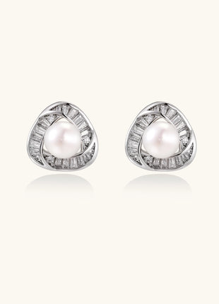 Close-up of triangular gold-plated stud earrings with central freshwater pearl surrounded by baguette crystals