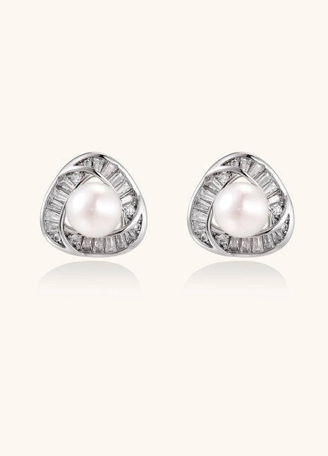 Close-up of triangular gold-plated stud earrings with central freshwater pearl surrounded by baguette crystals