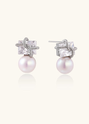Gold-plated stud earrings with square crystal tops wrapped in twisted wire and freshwater pearl drops on white background