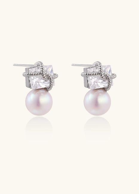 Gold-plated stud earrings with square crystal tops wrapped in twisted wire and freshwater pearl drops on white background